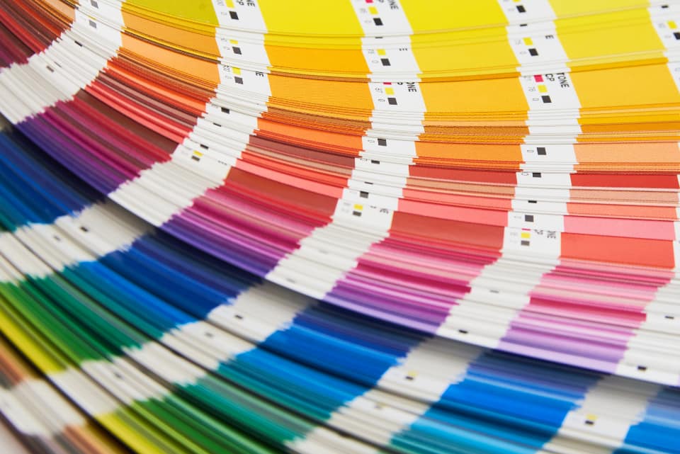 Designer comparing printed colour swatches against a screen