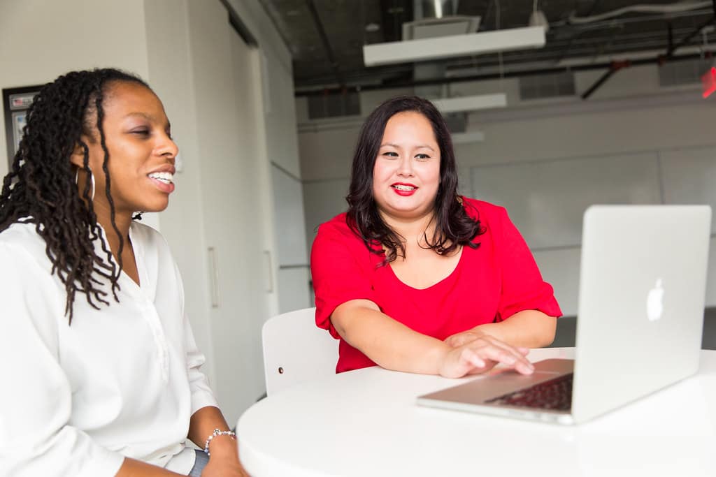 Designer and developer reviewing a website performance score on a monitor