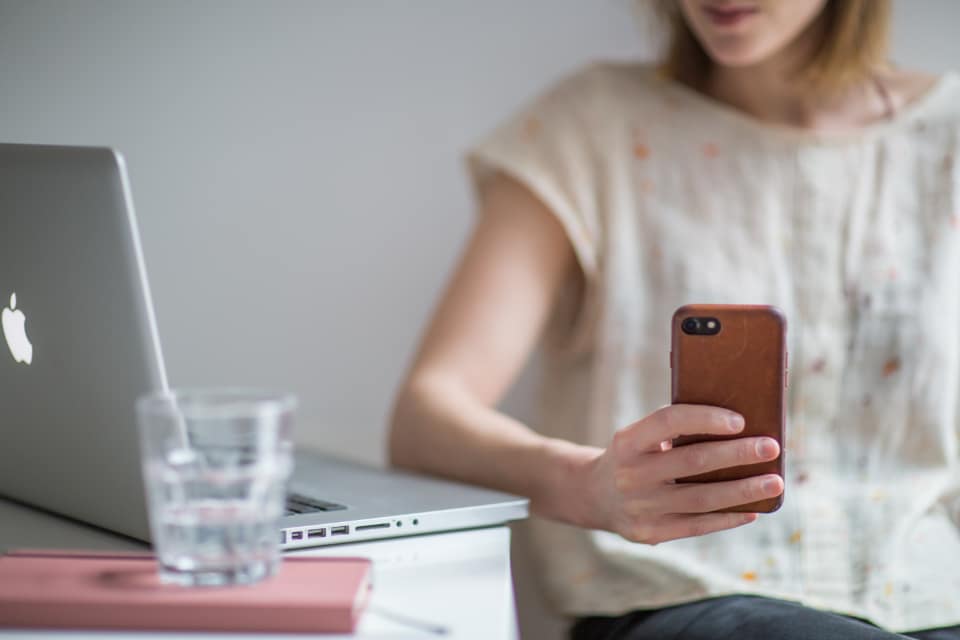 Business owner looking frustrated on the phone beside a laptop